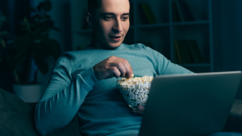 Uomo che guarda la televisione sul pc portatile